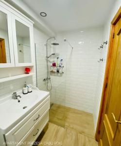 baño blanco con ducha y lavamanos en Casa BellaVista, en Orihuela