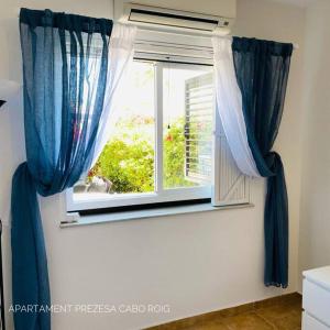 una ventana con cortinas azules en una habitación en Casa BellaVista, en Orihuela