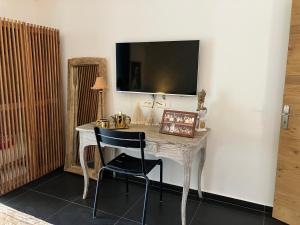 escritorio blanco con silla y TV en la pared en Maison "LA ROSALINDA-2B" Ghisonaccia, en Ghisonaccia