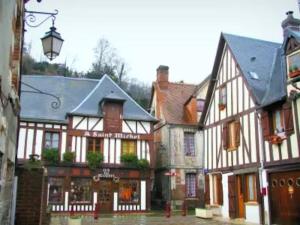 a group of buildings in a town with a street at Petit maison villageoise in Moulineaux