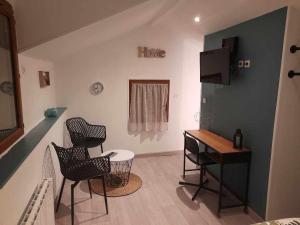 a living room with a table and chairs and a desk at Petit maison villageoise in Moulineaux
