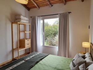 Un dormitorio con una cama verde y una ventana en Complejo Dulcería El Cazador y cabañas en Tandil