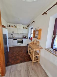 eine Küche mit weißen Schränken und einem Holztisch in der Unterkunft Ferienhaus Kleine Robbe in Friedrichskoog