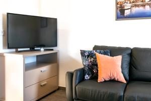 a living room with a black couch and a flat screen tv at Apartments Delic in Ražanac