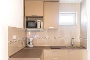 a kitchen with a microwave and a sink at Apartments Delic in Ražanac +10 photos