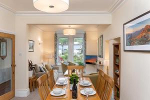 a dining room and living room with a table and chairs at Trewen Cottage in Conwy