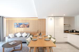 een woonkamer met een tafel en een bank bij La Cordée in Chamonix-Mont-Blanc