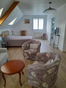 uma sala de estar com uma cama e um sofá em La Clé de Line em Saint-Aubin-sur-Mer