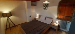 1 dormitorio pequeño con 1 cama con 2 luces en Gîte L'hirondelle, en Meyrueis