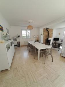 Il comprend une cuisine et un salon avec une table et des chaises. dans l'établissement La Clé de Line, à Saint-Aubin-sur-Mer