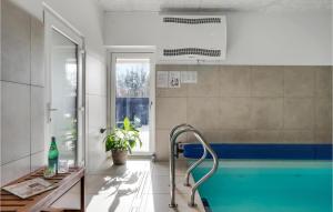 ein Bad mit einem Pool und einem Tisch in der Unterkunft Nice Home In Blokhus With Sauna in Blokhus