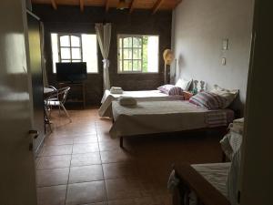 sala de estar con 2 camas y sofá en El Parralito en Luján de Cuyo