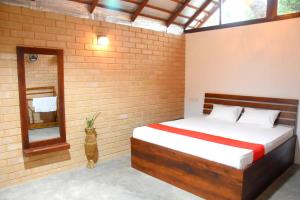 a bedroom with a bed in a brick wall at Ranathisara Grand Cabanas in Kurunegala