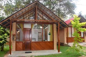 ein Haus mit einer Holzgarage mit einer Holztür in der Unterkunft Ranathisara Grand Cabanas in Kurunegala