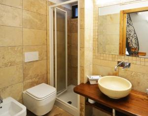 a bathroom with a sink and a toilet and a shower at La casetta degli agricoltori in Vetralla