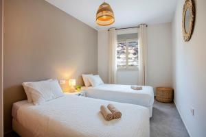 twee bedden in een kleine kamer met een raam bij Apartamento en Bolnuevo in Bolnuevo