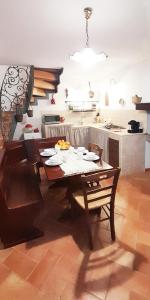 cocina con mesa de madera en una habitación en La casetta degli agricoltori, en Vetralla