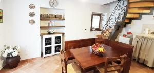 une salle à manger avec une table, des chaises et un escalier dans l'établissement La casetta degli agricoltori, à Vetralla