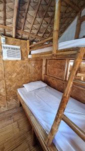 にあるEDVIL BEACH RESORTの木造家屋内のベッドルーム(二段ベッド2組付)