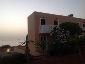 a house with the sunset in the background at Archipelagos Apartments in Arkasa