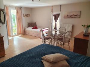 a bedroom with a bed and a table and chairs at Le relais de la cure in Saint-Juire-Champgillon +40 photos
