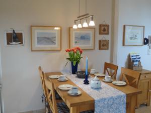 - une table à manger avec une bougie bleue dans l'établissement Ferienwohnung Seestern, à Vitte