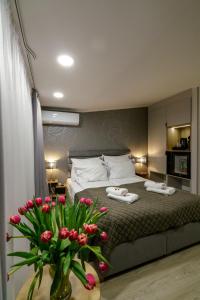 - une chambre avec un lit et un vase de fleurs dans l'établissement Kamienica no 111a, à Varsovie