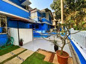 a blue house with a potted plant in a yard at Pinto Holiday Villas in Sangolda