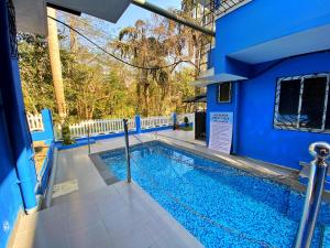 a swimming pool in a blue building with a blue house at Pinto Holiday Villas in Sangolda