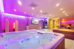 a large bath tub in a room with purple lighting at Privé Spa L'amour in Nuenen