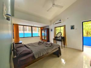 a bedroom with a bed and a desk and windows at Pinto Holiday Villas in Sangolda