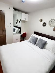 a bedroom with a large white bed with two pillows at Steff's Condo 2622 at One Oasis in Cagayan de Oro
