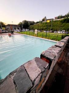 a large swimming pool with a stone wall around it at Steff's Condo 2622 at One Oasis in Cagayan de Oro