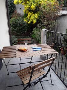 een houten tafel en een bank op een balkon bij Mimosa House in Turijn