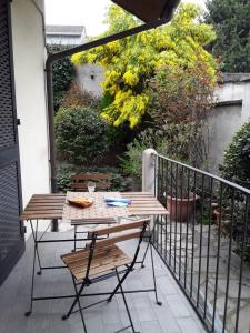 einen Holztisch und Stühle auf dem Balkon in der Unterkunft Mimosa House in Turin