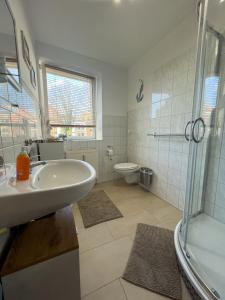 a bathroom with a sink and a shower and a toilet at Ferienwohnung Just Home in Wismar