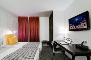 a hotel room with a bed and a television at Hotel Joyce - Astotel in Paris