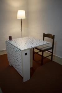 a table with a lamp and a chair in a room at Mimosa House in Turin