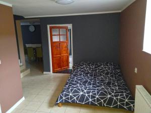um quarto com uma cama e uma parede castanha em Willa Raj - Apartamenty nad jeziorem KA-BOATS em Rajgród