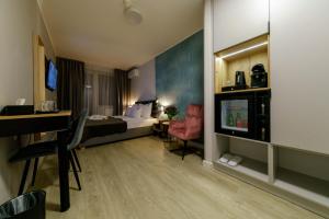 a hotel room with a bed and a desk and a television at Kamienica no 111a in Warsaw