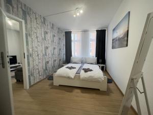 a bedroom with a white bed and a window at Ferienwohnung Just Home in Wismar