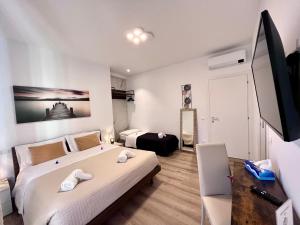 een slaapkamer met 2 bedden en een flatscreen-tv bij verona rooms 109 in Verona