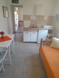 eine Küche mit einem Sofa und einem Tisch sowie eine Küche mit einem Waschbecken in der Unterkunft Gospava Apartman in Igalo