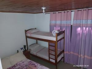 Schlafzimmer mit Etagenbett und lila Vorhängen in der Unterkunft Miguel Departamentos 1 in Puerto Iguazú
