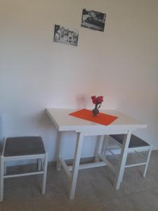 ein weißer Tisch mit einer Vase Blumen drauf in der Unterkunft Gospava Apartman in Igalo