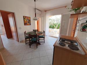 a kitchen and dining room with a table and a stove at Olive garden Pag in Pag