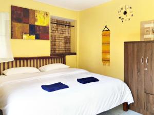ein Schlafzimmer mit einem Bett mit zwei blauen Kissen darauf in der Unterkunft Blue Beach Resort in Baanphakrimlay 