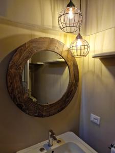 a bathroom with a mirror and a sink and lights at B&B L'Orto Sul Tetto in Ragusa