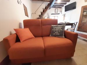 eine orangefarbene Couch mit einem Kissen darüber in der Unterkunft *La Torre Di Amelia* Nel Cuore Dell' Umbria in Amelia
