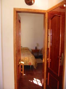 sypialnia z łóżkiem i drzwiami prowadzącymi do pokoju w obiekcie Casa Time w mieście Tijarafe